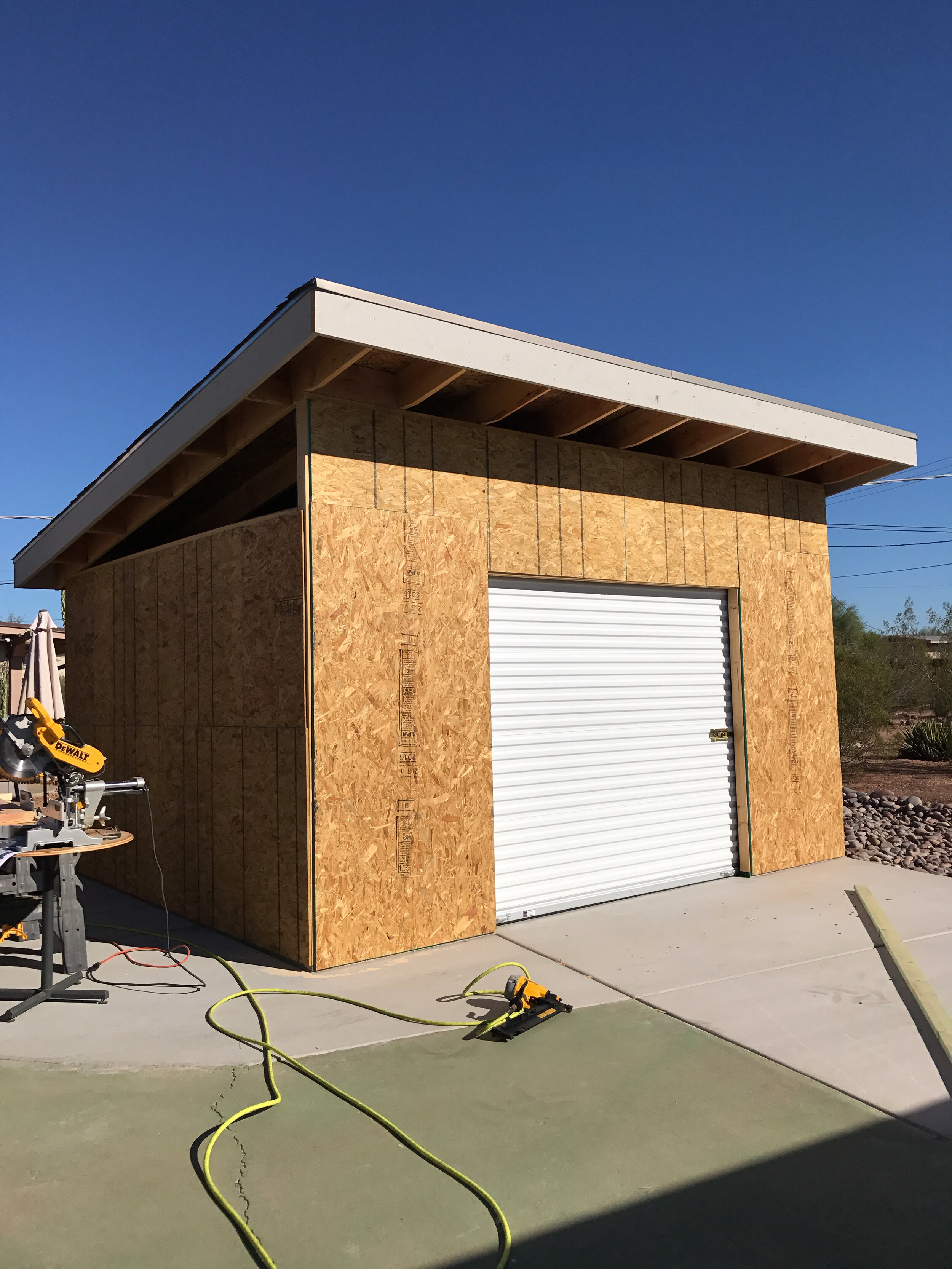 Roof on, steel roll-up door installed